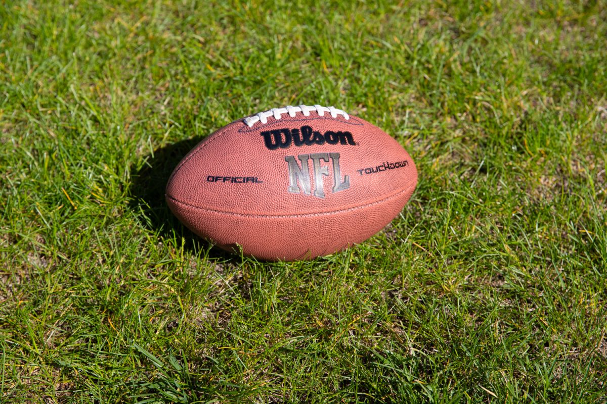 Photo illustration of a football in the grass. 